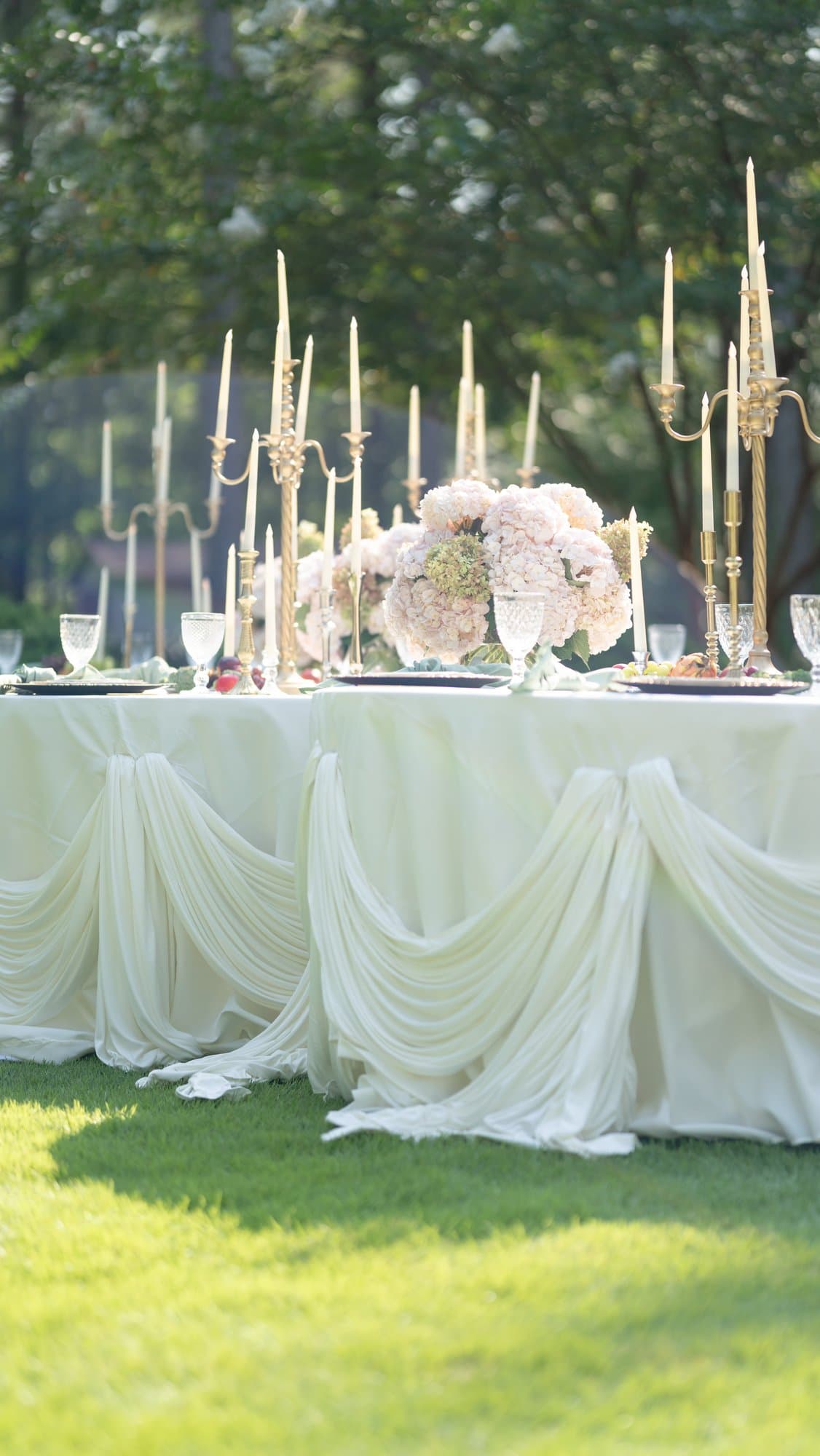 Swag-draped table skirting with gold candelabra rows