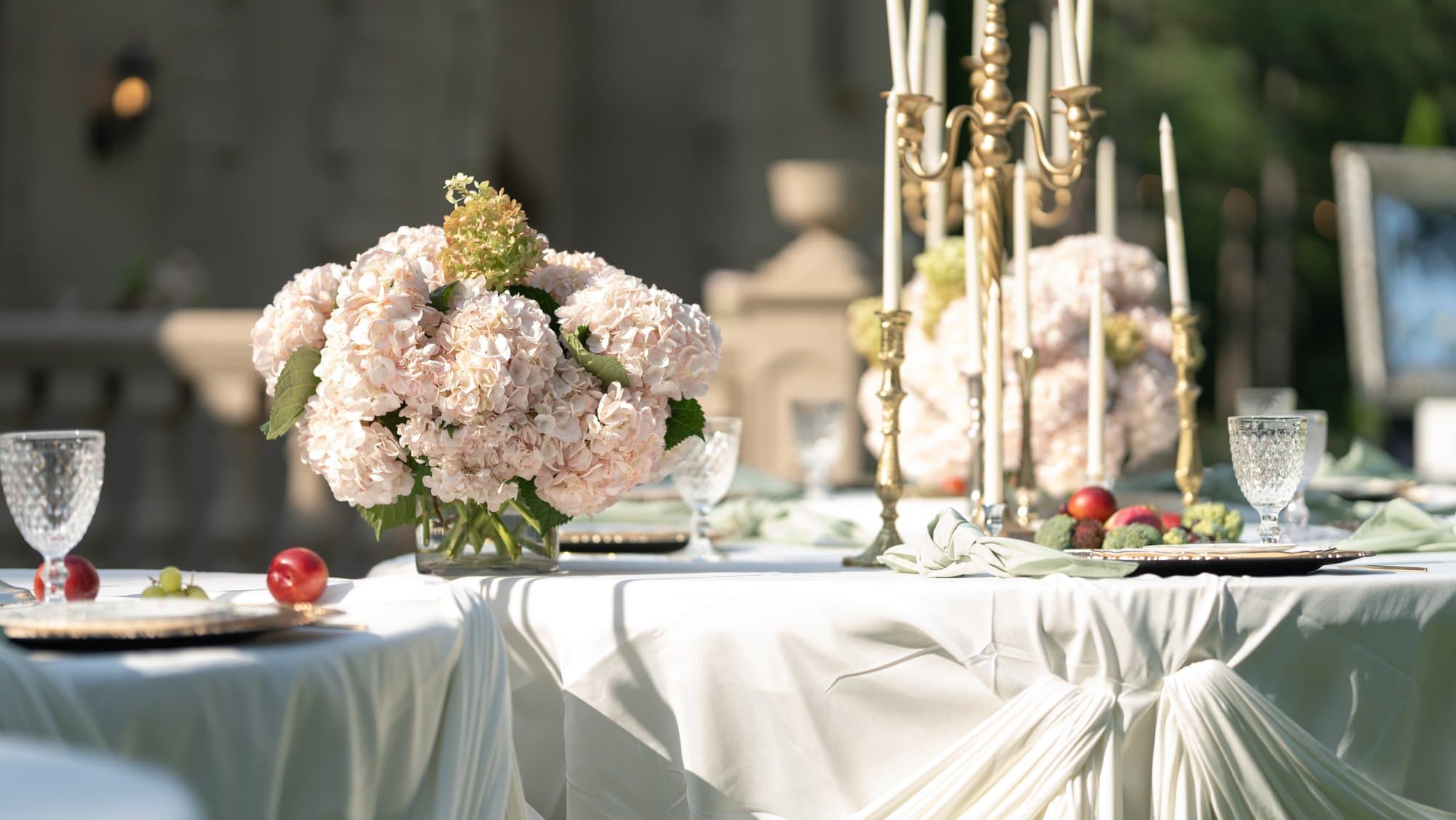 Draped reception tablescape with blush hydrangea and gold candelabra