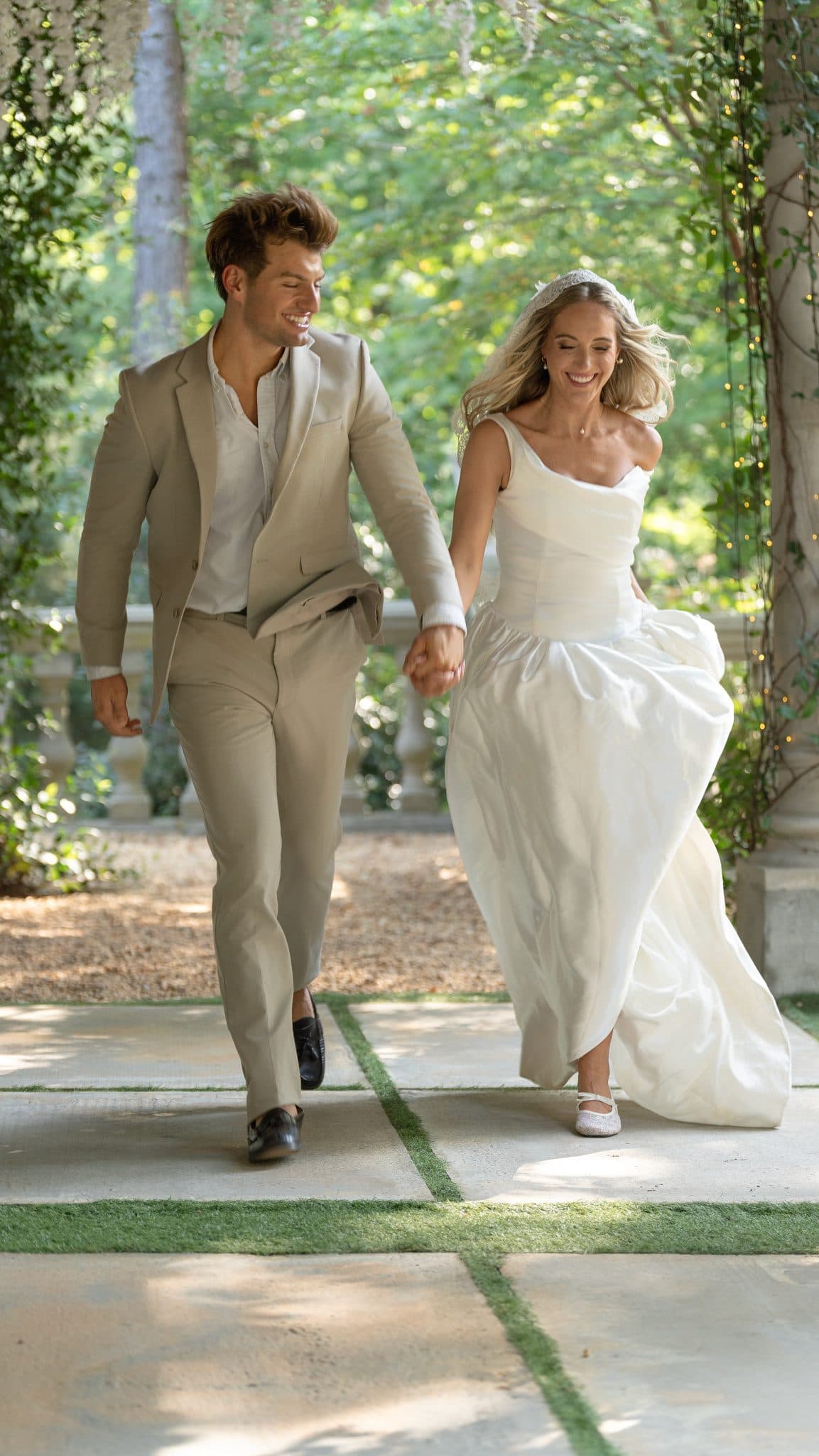 Couple running hand in hand beneath the wisteria, The Castle at WildWood